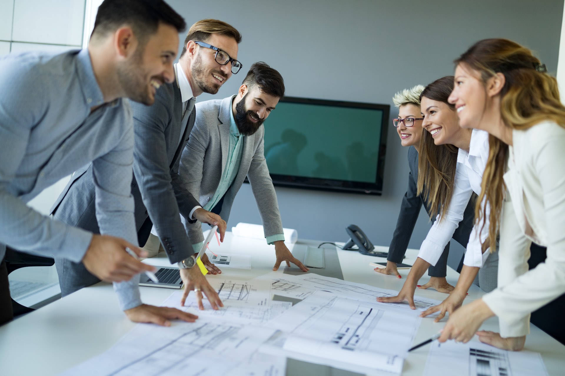 Team of architects working on construction plans Team of architects working on construction plans together