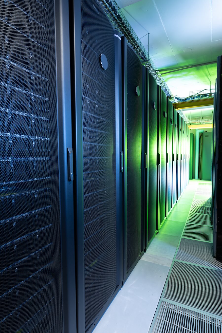 Data center with multiple rows of fully operational server racks. modern cloud computing technology concept.