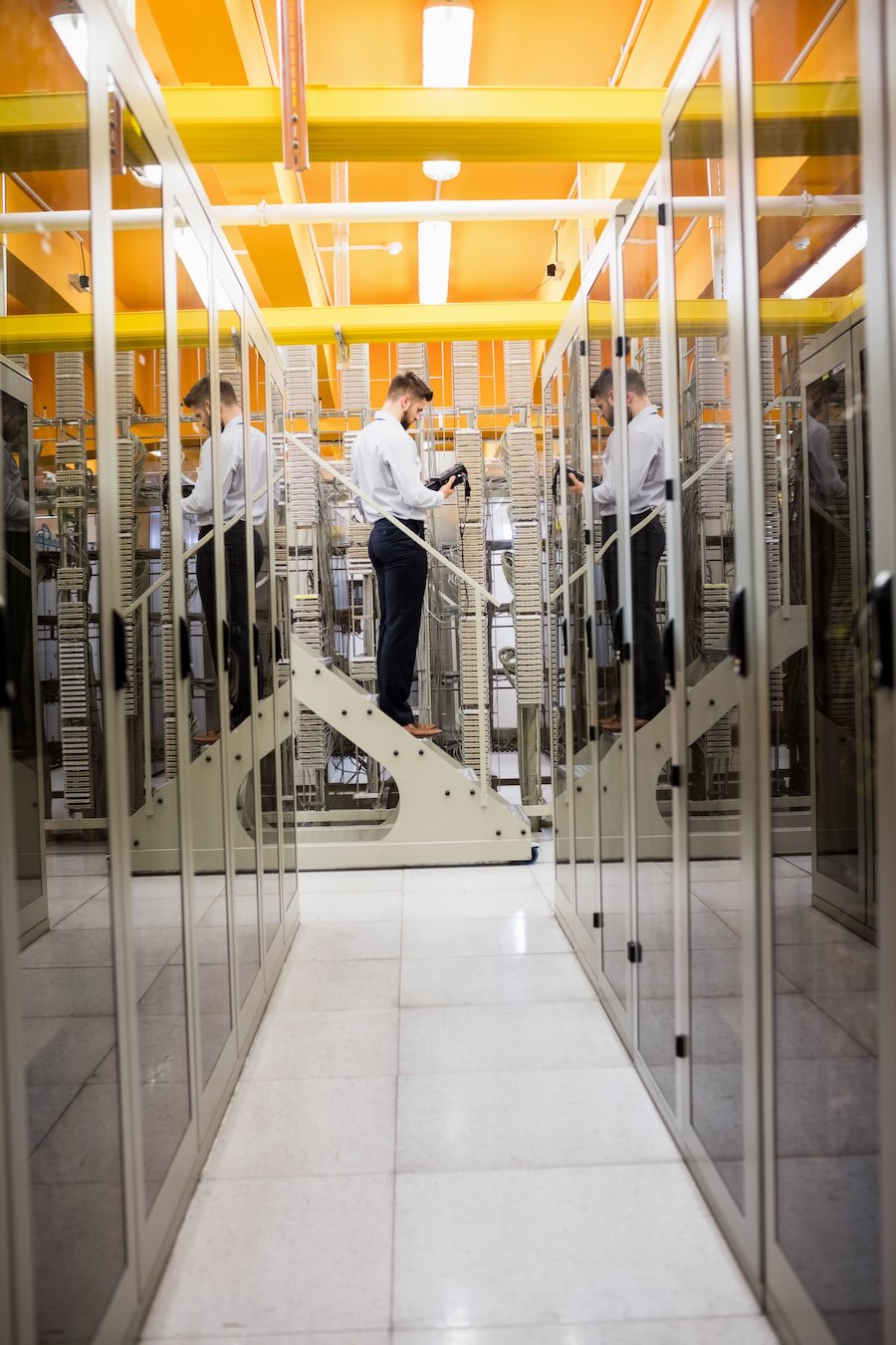 Technician using digital cable analyzer in server room