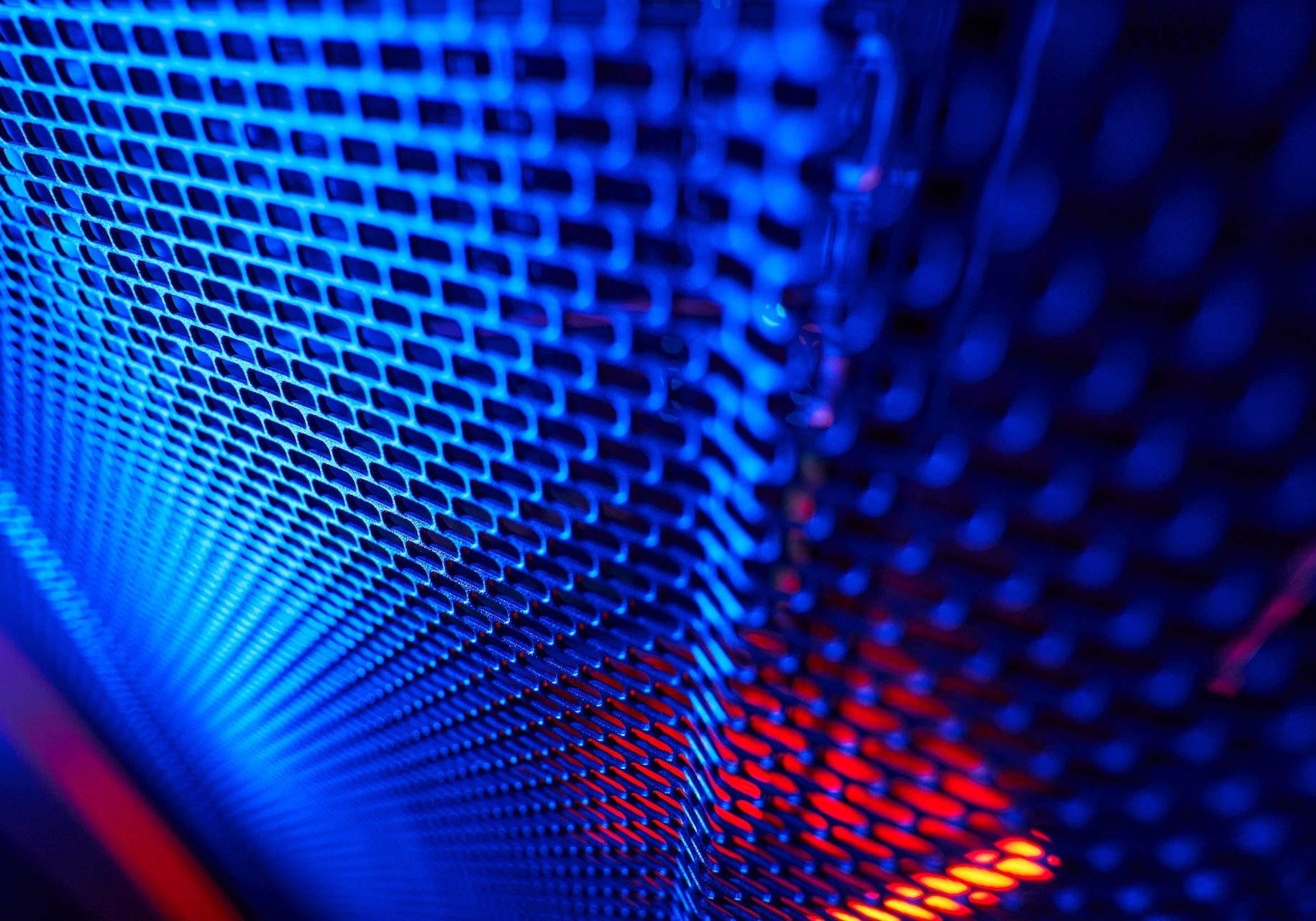 Modern interior of tech room in data center Close up portrait of metal panel of server rack in dark room with blue and pink neon lights